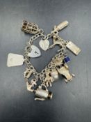 A silver charm bracelet with a variety of charms, approximate weight 47g.
