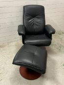 A leather swivel recliner chair with foot stool