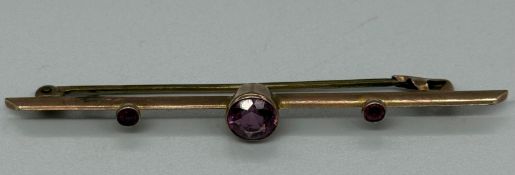 A 9ct gold brooch with three amethyst style stones, approximate weight 2.9g