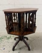 An oak revolving bookcase, Arts and Crafts octagonal bookcase with tulip cutouts (H67cm Dia51cm)