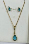 An 18ct gold blue stone pendant and earring set