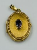 A 9ct gold locket with inset amethyst, approximate weight 2.3g