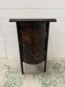 A vintage black painted bedside cabinet in a barrel form with square top, the door opening to two