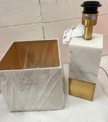 A white and gold tone table lamp