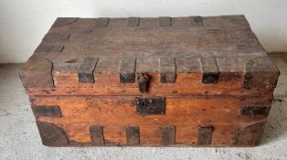 A wooden travel trunk with metal banding and handles to each end (H37cm W84cm D46cm)