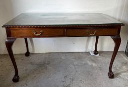 A red leather topped mahogany writing desk with two drawers on cabriole legs with claw and ball feet