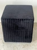 Two modern cube footstools, one upholstered in orange and the other in black.