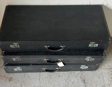 Three long black suitcases, each lined with linen.