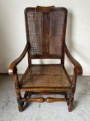 An oak cane back and seated armchair with scrolling arms