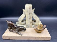 A pair of onyx carved bookends together with a desk lamp featuring a dog on a marble plinth
