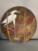 A circular ceramic Raku wall plaque depicting an Egret in the Reeds by Tom and Nancy Giusti (Dia