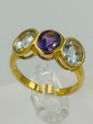 A silver gilt three stone dress ring with amethyst and aquamarine approximate size N