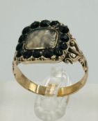A George III memorial ring with a framed lock of hair and weight of 4.3g engraved to back John