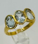 A silver gilt three stone aquamarine style ring approximate size N