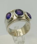 A silver three stone amethyst style dress ring with three stones approximate size N.
