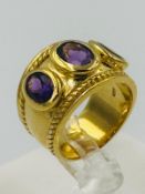A silver gilt three stone amethyst style ring with three stones approximate size N.