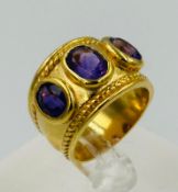 A silver gilt three stone amethyst dress ring, approximate size N