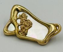 A 9ct gold brooch with mother of pearl and an approximate weight of 11g.