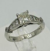 A diamond single stone ring with diamond set shoulders and mount. Princess cut diamond approximate
