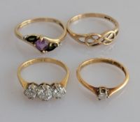 A three-stone diamond ring, the largest round-cut central diamond approximately 0.25 carats