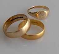 A 22ct yellow gold wedding band, 5mm, 6.4g, another gold wedding band, 7mm and a gold signet ring