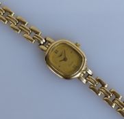 A ladies Longines quartz wristwatch with gold dial, baton markers in a gold case and bracelet strap