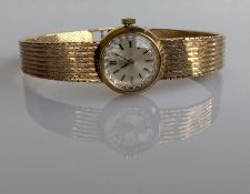 A 1960s ladies Omega manual wristwatch with baton markers on an integrated  9ct yellow gold textured