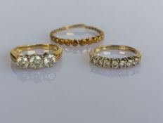 A three-stone diamond ring on a yellow gold tapering shank, hallmarked 750, total diamond weight