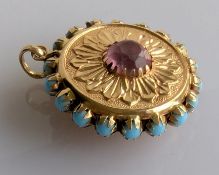 An embossed yellow gold double sided medallion with turquoise and gem-set decoration, 35mm diameter