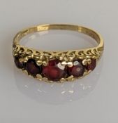 A Victorian-style yellow gold ring with five graduated garnets, largest approximately 0.50 carats