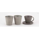† JONO SMART; a stoneware espresso cup and saucer covered in grey glaze, impressed J marks, cup