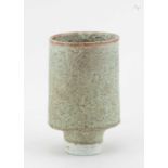 † DEREK DAVIS (1926-2008); a tall oval porcelain cup form covered in mottled celadon glaze with iron