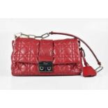 DIOR; a deep red calfskin leather new lock flap bag from the Miss Dior line, with iconic cannage