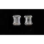 A pair of emerald cut diamond ear studs in white metal frame, unmarked, test as platinum on Thermo