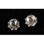 A pair of diamond solitaire ear studs in white metal frames, unmarked, test as 17.9kt gold on Thermo