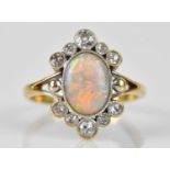 An 18ct yellow gold diamond and opal cluster ring, set with ten old cut diamonds and central opal,
