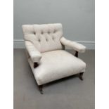 A library chair in the manner of Howard & Sons, with button back upholstery, on turned legs, with