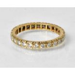 A yellow metal eternity ring set with diamonds, size W, approx. 4.4g. Provenance: - From the