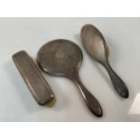 A George V hallmarked silver three piece dressing table set, with engine turned decoration,