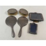M. C; a pair of George V hallmarked silver brushes, Birmingham 1911, together with a hand mirror