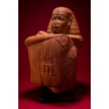 EGYPTIAN RED QUARTZITE BLOCK STATUE OF A PRIEST, POSSIBLY YUYA, PRIEST OF MIN AND FATHER OF QUEEN TI