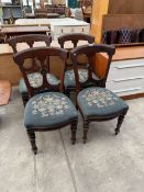 A SET OF FOUR VICTORIAN MAHOGANY DINING CHAIRS ON TURNED AND FLUTED FRONT LEGS WITH FLORAL
