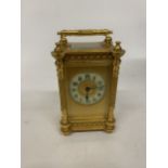 A FRENCH GILT BRASS CARRIAGE CLOCK WITH REEDED COLUMNS, ORNATE GILT FRETWORK PANELS, ENAMEL