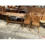 AN ERCOL REFECTORY STYLE ELM TABLE AND FOUR WINDSOR STYLE CHAIRS, ONE BEING A CARVER
