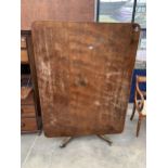 A 19TH CENTURY MAHOGANY TILT TOP BREAKFRONT/DINING TABLE ON PEDESTAL BASE WITH BRASS CAPPED CASTORS,