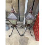 A PAIR OF ORNATE VINTAGE COPPER OUTSIDE LANTERNS WITH WROUGHT IRON STANDS