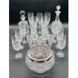 A collection of various glassware including two decanters, selection of cut glass champagne flutes