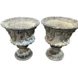 A pair of reconstituted stone planters on plinths with floral and animal motifs, one has a small