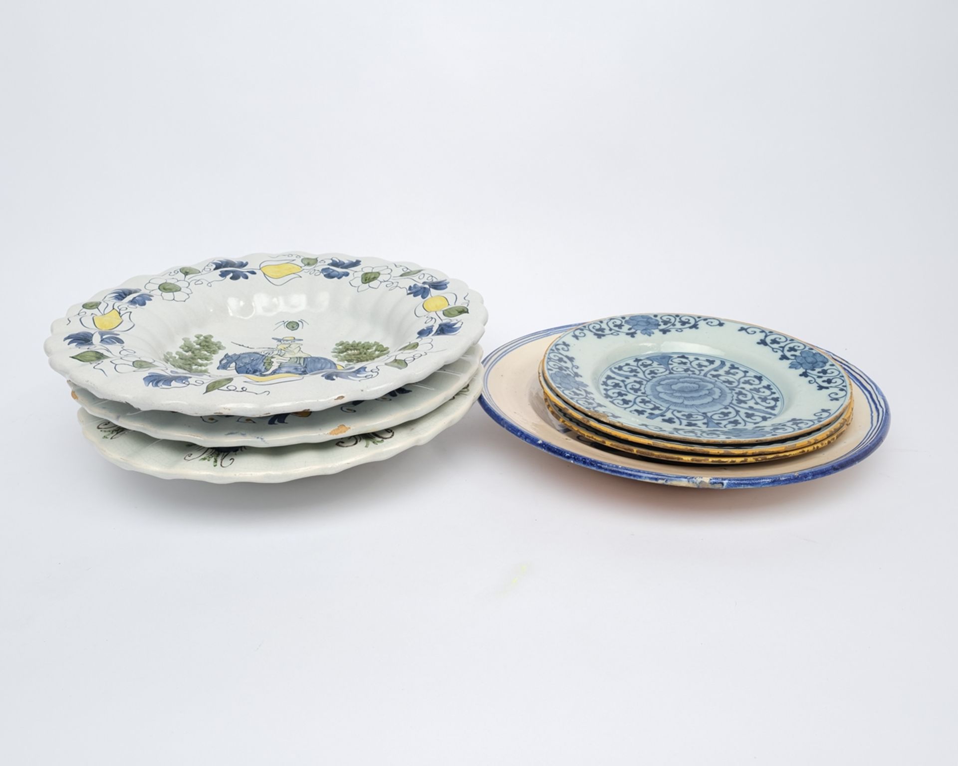 Konvolut 3 Teller und 4 Platten, Fayence, diverse Motive und Dekore, ø ca. 23-32 cm, Randabplatzung