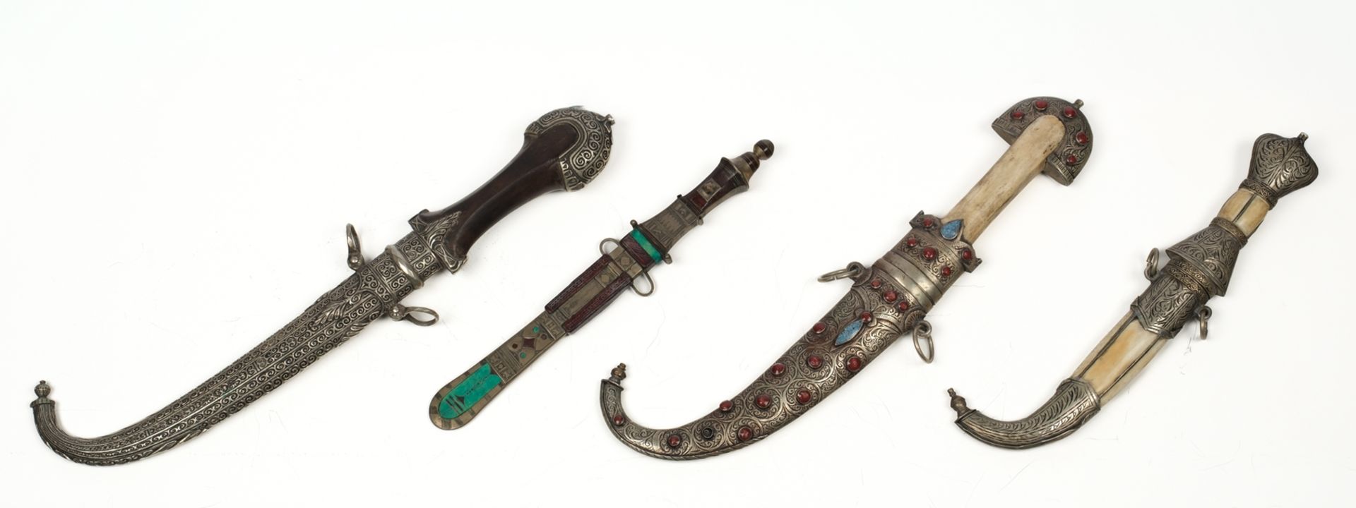 Konvolut von vier orientalischen Dolchen, 19./20. Jh., Griffe mit Holz, Bein und Silber, Scheiden t